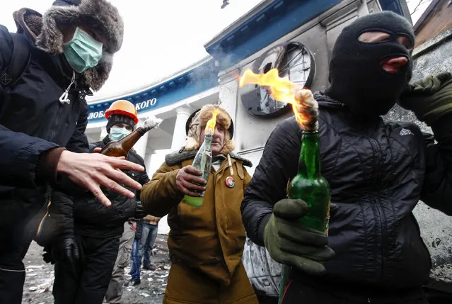 Pro-European integration protesters carry Molotov cocktails during clashes with police in Kiev January 20, 2014. (Photo by Vasily Fedosenko/Reuters)