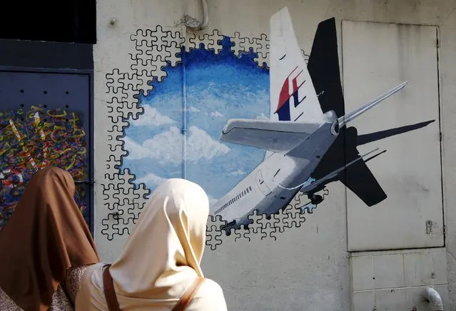 Women look at a mural of missing Malaysia Airlines flight MH370 two years after it disappeared, in Kuala Lumpur, Malaysia, March 7, 2016. (Photo by Olivia Harris/Reuters)