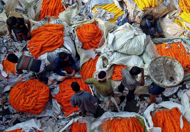 Vendors sell marigold garlands used to decorate homes and temporary platforms during the festival of Saraswati Puja, at which Hindu devotees pray to Saraswati, the Hindu goddess of knowledge and learning, in Kolkata, India January 31, 2017. (Photo by Rupak De Chowdhuri/Reuters)
