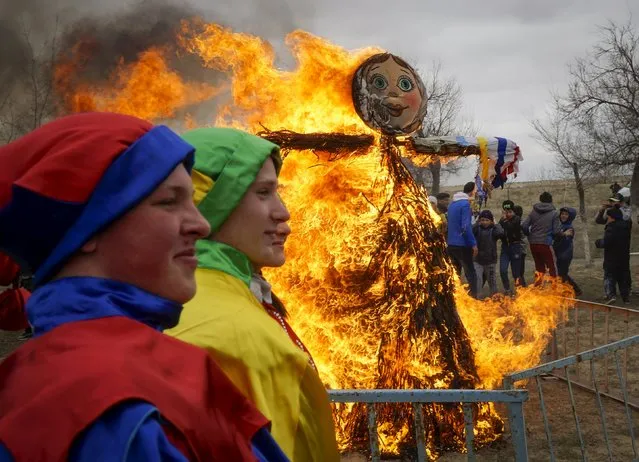 Artists watch burning an effigy of Lady Maslenitsa as they celebrate Maslenitsa, or Pancake Week, in Baikonur, Kazakhstan, March 13, 2016. (Photo by Shamil Zhumatov/Reuters)