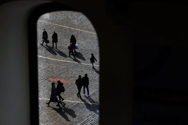 People walking across Red Square are seen through the window of a vaccination centre in the State Department Store, GUM, amid the outbreak of the coronavirus disease (COVID-19) in Moscow, Russia on October 26, 2021. (Photo by Evgenia Novozhenina/Reuters)