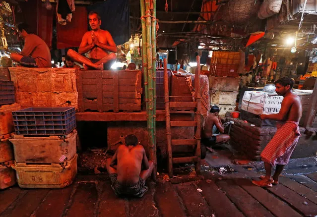 A worker prays as others prepare to take a bath at a wholesale fish market in Kolkata, India February 9, 2017. (Photo by Rupak De Chowdhuri/Reuters)