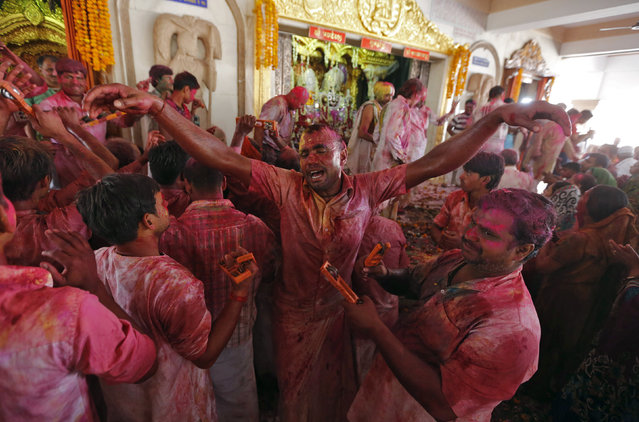 Hindu devotees daubed in colours sing religious songs inside a temple during Holi celebrations in Ahmedabad, India, March 23, 2016. (Photo by Amit Dave/Reuters)