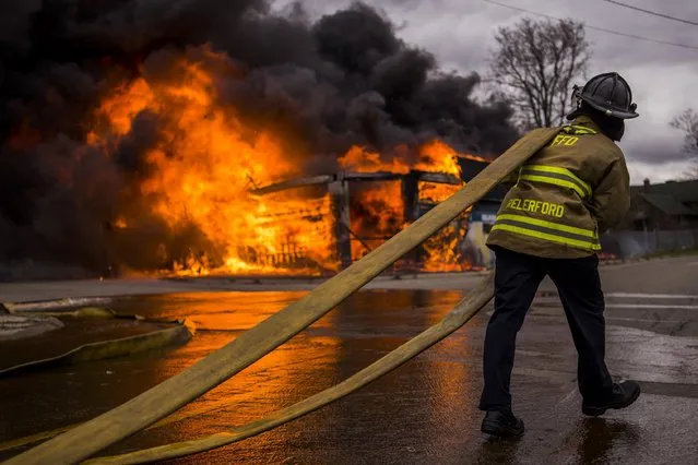 Flint firefighters work to contain a large fire that engulfs a former strip club, once called The Body Shop, Wednesday, April 22, 2015 at the intersection of Glenwood Avenue and Asylum Street, sending a large plume of black smoke over the city of Flint. (Photo by Jake May/The Flint Journal-MLive.com via AP Photo)