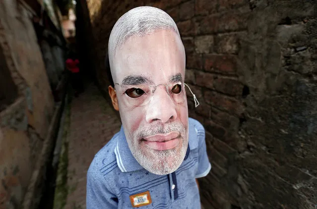 A boy wears a mask of India’s Prime Minister Narendra Modi in an backalley before his arrival to a roadshow in Varanasi, India, April 25, 2019. (Photo by Adnan Abidi/Reuters)
