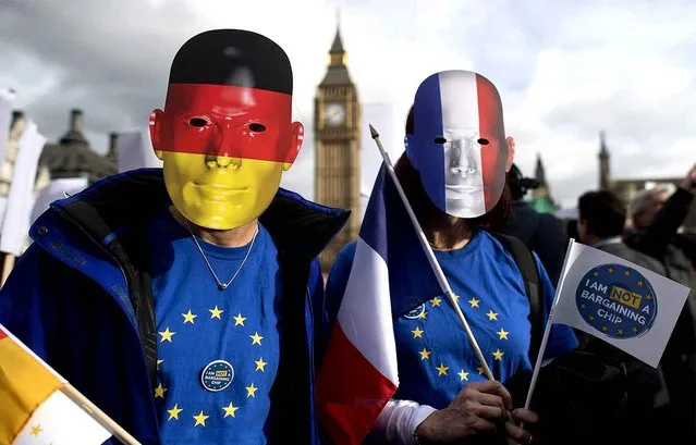 Protesters wearing German and French flag face masks pose for a photograph during a “Flag Mob” demonstration in Parliament Square in central London on February 20, 2017, part of a national day of action in support of migrants in the UK. Under the banner “One Day Without Us” men, women and children come together for a day of action to stress that they want Britain to remain open and welcoming. A number of businesses closed for the day to make the point that the Britain couldn’t manage for even one day without the contribution of migrants. (Photo by Justin Tallis/AFP Photo)