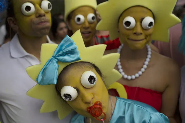 Revelers wearing costumes depicting “The Simpsons” comic characters pose for the photo during the “Ceu na Terra” or Heaven on Earth street party in Rio de Janeiro, Brazil, Saturday, February 25, 2017. Merrymakers take to the streets in hundreds of open-air “bloco” parties during Rio's over-the-top Carnival, the highlight of the year for many. (Photo by Leo Correa/AP Photo)