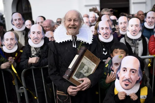 People hold up face masks with William Shakespeare's portrait during celebrations to mark the 400th anniversary of the playwright's death in the city of his birth, Stratford-Upon-Avon, Britain, April 23, 2016. (Photo by Dylan Martinez/Reuters)