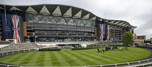 Gatekeeprs assemble for a group photograph in the parade ring on the second day of  Royal Ascot horse racing meet at Ascot, England, Wednesday, June 17, 2015. Royal Ascot is the annual five-day horse race meeting that Britain's Queen Elizabeth II attends every day of the event. (AP Photo/Alastair Grant)