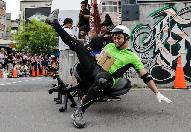A reveler falls from the chair as he participates in the office chair racing in Tainan city, southern Taiwan, 24 April 2016. Around 300 participants, mostly Taiwanese and Japanese, joined the event. Office chair racing started in Japan in 2010 and it is the first time to be held in Taiwan. According to Erik Kao, the event organizer, he wants to share the enjoyment of the race to everyone. (Photo by Ritchie B. Tongo/EPA)