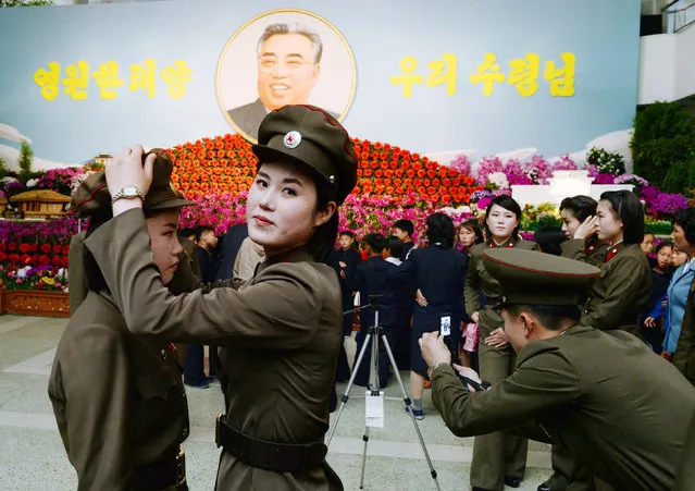 North Korean female soldiers prepare to take a commemorative photograph in front of a flower exhibition featuring North Korea's late founder Kim Il Sung in Pyongyang, in this photo taken by Kyodo on April 14, 2014 and released on April 15, 2014, on the 102nd birthday of North Korean founder Kim Il Sung. (Photo by Reuters/Kyodo)