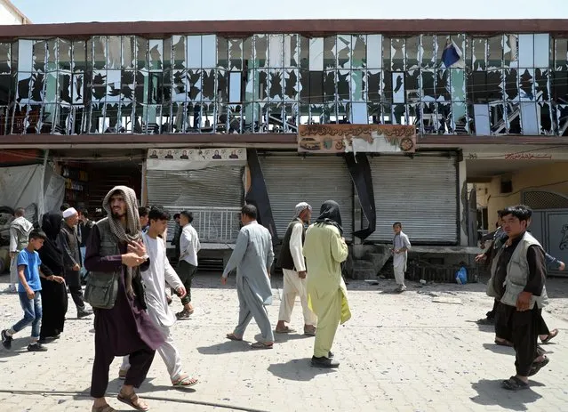 People walk in front of a building with broken windows at the site of a car bomb blast in Kabul, Afghanistan, August 7, 2019. (Photo by Omar Sobhani/Reuters)