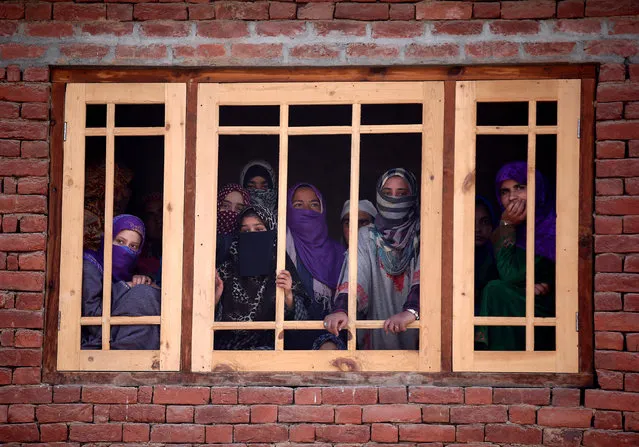 Women watch the funeral of Rayees Ahmad Wani, a suspected militant who according to local media was killed in Padgampora in an encounter with the Indian security forces on Sunday, in Bellow village in south Kashmir, March 27, 2017. (Photo by Danish Ismail/Reuters)
