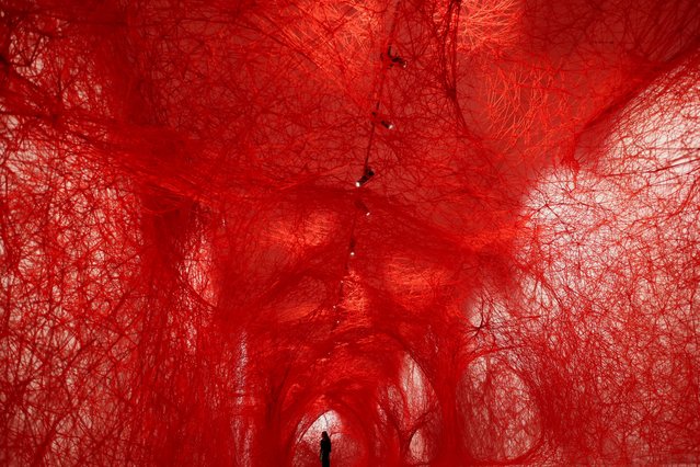 A woman stands inside the art piece “The network”, by the Japanese artist Chiharu Shiota (Gallery Templon), exhibited in the Museum of Tapestries, in Aix-en-Provence, France, on May 17, 2024. (Photo by Manon Cruz/Reuters)
