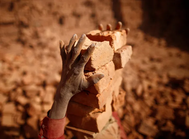 A worker stacks bricks on his head at a brick factory in Lalitpur, Nepal February 7, 2017. (Photo by Navesh Chitrakar/Reuters)