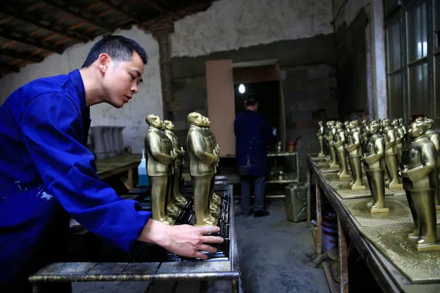 A Chinese worker adjusts Mao Zedong statues at a factory in Shaoshan, Hunan Province in central China, 29 April 2016. (Photo by How Hwee Young/EPA)