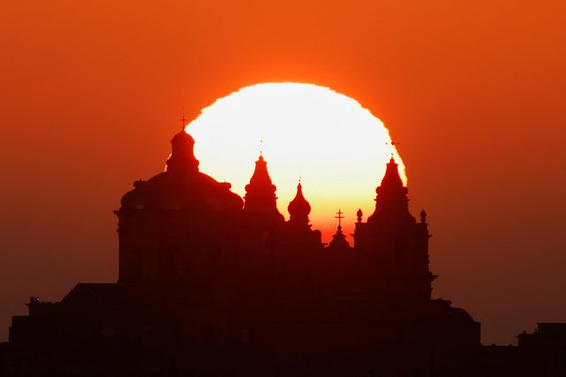 The sun rises behind the Metropolitan Cathedral of Saint Paul in the medieval fortified city of Mdina, Malta, January 2, 2022. (Photo by Darrin Zammit Lupi/Reuters)