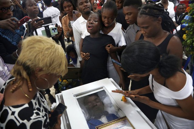 Relatives pay their final respects as they gather around the coffin that contains the remains of Saintus Leodens who was killed by unknown assailants, during his burial service in Port-au-Prince, Haiti, May 25, 2024. (Photo by Odelyn Joseph/AP Photo)