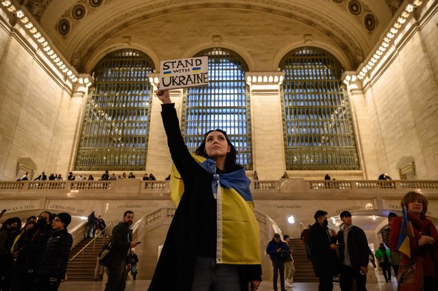 Activists hold placards during a protest in solidarity with Ukraine, at Grand Central Station in New York on March 23, 2022. (Photo by Ed Jones/AFP Photo)