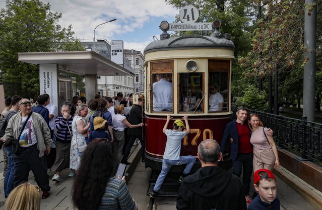 People look at a vintage Kolomna Motor tram car (1926-1935) during the street exhibition Retro Transport Parade at Chistoprudny Boulevard in Moscow, Russia, 04 June 2022. Trams of different generations, MAZ and GAZ trucks from the collection of the Moscow Transport Museum, as well as cars and motorcycles of the Soviet era took part in the Retro Transport Parade. For the first time, exhibits from the museum of the Special Purpose Garage of the Federal Security Service of Russia (FSO) featured in the parade. (Photo by Yuri Kochetkov/EPA/EFE)