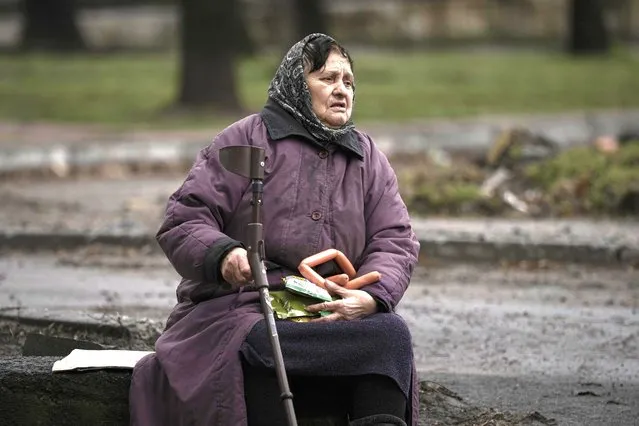 A woman holds food items she received after a convoy of military and aid vehicles arrived in the formerly Russian-occupied Kyiv suburb of Bucha, Ukraine, Saturday, April 2, 2022. As Russian forces pull back from Ukraine's capital region, retreating troops are creating a “catastrophic” situation for civilians by leaving mines around homes, abandoned equipment and “even the bodies of those killed”, President Volodymyr Zelenskyy warned Saturday. (Photo by Vadim Ghirda/AP Photo)