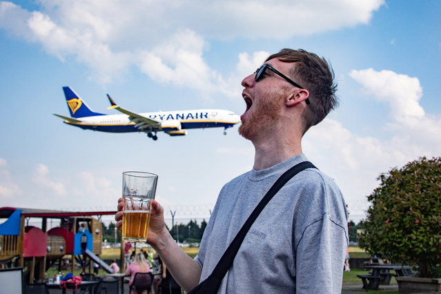 Fraser Davidson gobbles a plane at The Hangar at Manchester Airport on June 26, 2024. An airport pub serves drinks just 15 metres from the runway – and drinkers can watch planes coming into land over a pint. The Hangar, Manchester, is 50 feet away from the airport, and people don't need to be checked in to drink there. It boasts a “unique perspective” for customers, who can enjoy a pint right next to planes taking off and landing. (Photo by South West News Service)