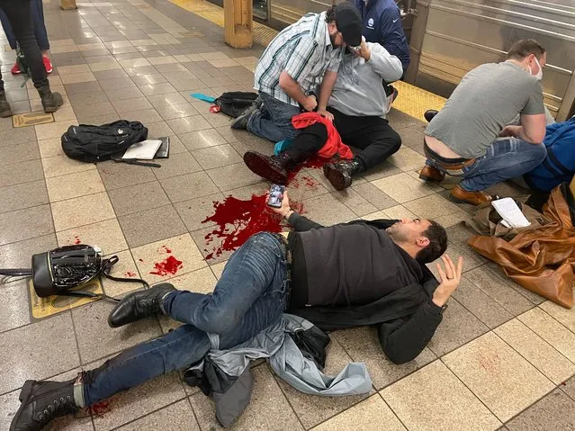 New Yorkers on their way to work treat victims of a shooting on the Manhattan bound platform of the 36th Street N,R,and D station in Brooklyn, Sunset Park, Brooklyn, NY, USA on April 12, 2022. (Photo by Derek French/EPA/EFE/Rex Features/Shutterstock)