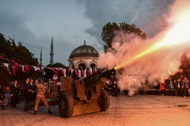 Turkish soldiers fire a military cannon to mark the end of the day's fasting period on May 27, 2017 at the Blue Mosque Square in Istanbul, during the first day of the holy month of Ramadan. The world's nearly 1.5 billion Muslims on May 27 began Ramadan, the holy month of dawn-to-dusk fasting and prayers. It is sacred to Muslims because tradition says the Koran was revealed to the Prophet Mohammed during that month. (Photo by Ozan Kose/AFP Photo)