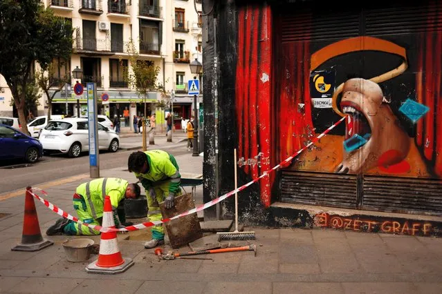 Workers do maintenance work next to a closed down bar in Madrid, Spain, April 5, 2022. (Photo by Susana Vera/Reuters)