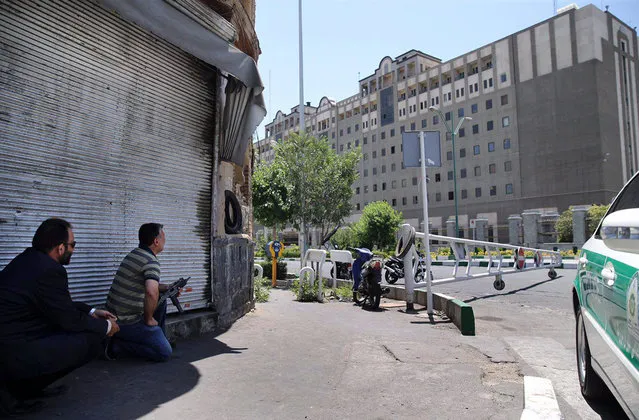 Security personnel take position in front of Iran's parliament building after an assault by several attackers, in Tehran, Iran, Wednesday, June 7, 2017. Suicide bombers and gunmen stormed into Iran's parliament and targeted the shrine of Ayatollah Ruhollah Khomeini on Wednesday, killing a security guard and wounding several other people in rare twin attacks, with the siege at the legislature still underway. (Photo by Omid Vahabzadeh/AP Photo/Fars News Agency)