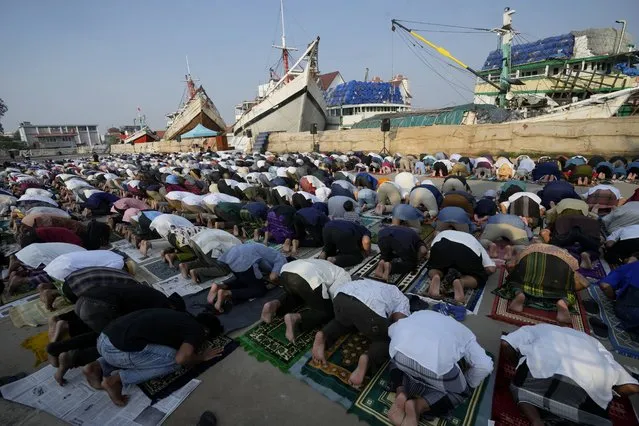 Muslim men offer Eid al-Fitr prayers to mark the end of the holy fasting month of Ramadan at Sunda Kelapa port in Jakarta, Indonesia, Monday, May 2, 2022. (Photo by Tatan Syuflana/AP Photo)