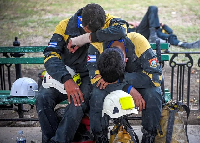 Members of the rescue brigade rest after a work shift at the Saratoga Hotel days after a huge blast wrecked the building, in Havana, on May 11, 2022. The death toll from an explosion at the luxury hotel in the old quarter of Havana has risen to 43. Crews continued to comb through the rubble of the Saratoga five-star hotel, which was being renovated and had no guests at the time of the late-morning blast last Friday that was seemingly caused by a gas leak. (Photo by Yamil Lage/AFP Photo)