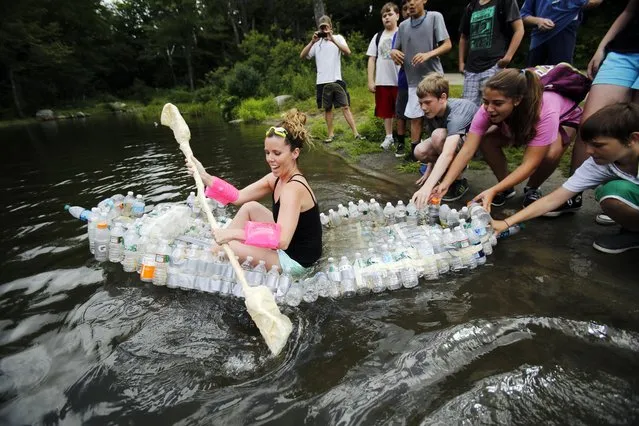 Herberg Middle School teacher Mallory Reddy successfully floats in her team's kayak at North Pond in the Savoy Mountain State Forest in Florida, Mass., Wednesday, August 5, 2015. Students from the Reid and Herberg Middle School summer programs built the kayaks out of recycled bottles and other recycled school materials as their final project of the 3-week-long programs funded through the 21st Century Community Learning Center. (Photo by Stephanie Zollshan/The Berkshire Eagle via AP Photo)