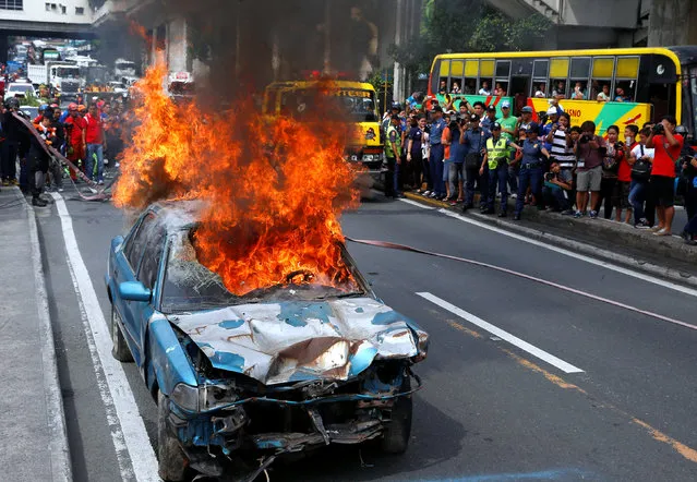 A car burns to simulate an earthquake aftermath during a metrowide earthquake drill along main highway EDSA in Makati, Metro Manila, Philippines June 22, 2016. (Photo by Erik De Castro/Reuters)