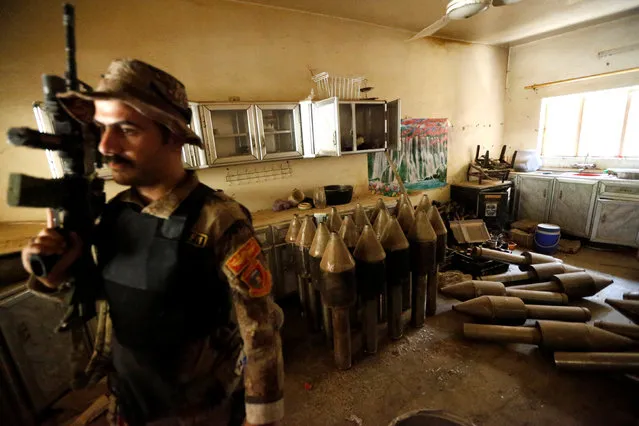 A member of the Iraqi counterterrorism forces stands by an Islamic State militants weapons factory in Falluja, Iraq, June 23, 2016. (Photo by Thaier Al-Sudani/Reuters)