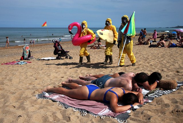 Environmental activists from the Bizi and Surf Rider Foundation protest in Bidart's beach, southwestern France, Sunday, July, 23, 2023. The protest is against the pollution of bathing waters. (Photo by Bob Edme/AP Photo)