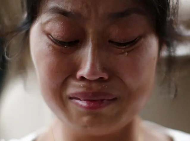 Liu Ling, whose husband was onboard Malaysia Airlines Flight MH370 which disappeared on March 8, cries during an interview with Reuters in Beijing July 18, 2014. World leaders demanded an international investigation into Thursday's shooting down of Malaysia Airlines Flight MH17 with 298 people on board over eastern Ukraine in a tragedy that could mark a pivotal moment in the worst crisis between Russia and the West since the Cold War.(Photo by Kim Kyung-Hoon/Reuters)