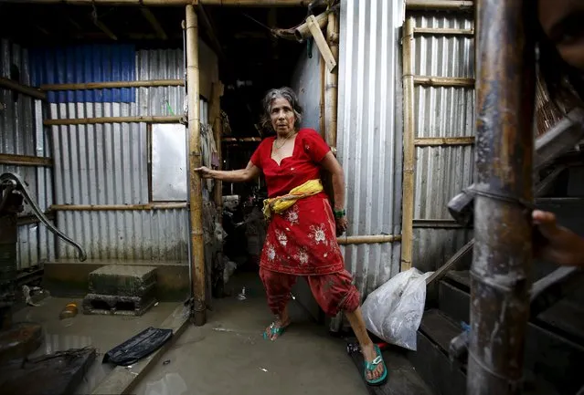 A woman walks out from her shed near floodwaters caused by heavy rainfall flowing from the swollen Bagmati River in a slum in Kathmandu, Nepal August 17, 2015. (Photo by Navesh Chitrakar/Reuters)