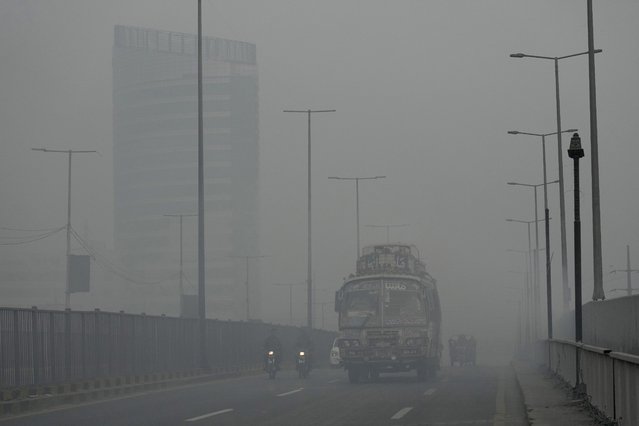 Vehicles move slow on a road as smog envelops the area, in Lahore, Pakistan, Monday, October 28, 2024. (Photo by K.M. Chaudary/AP Photo)