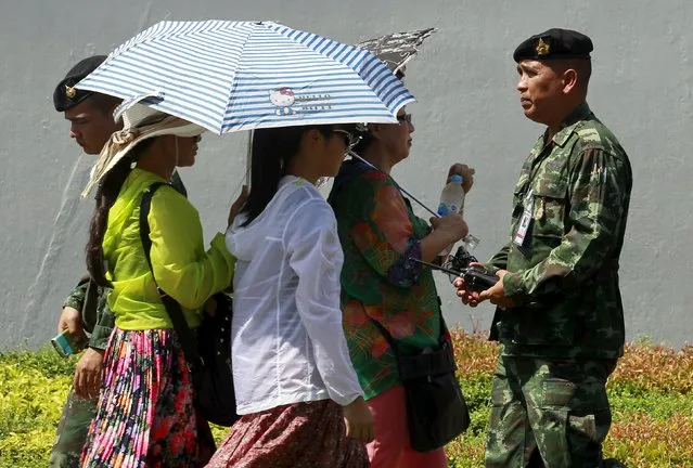 A soldier walks past tourists near the Grand Palace in Bangkok, Thailand, August 18, 2015. (Photo by Chaiwat Subprasom/Reuters)