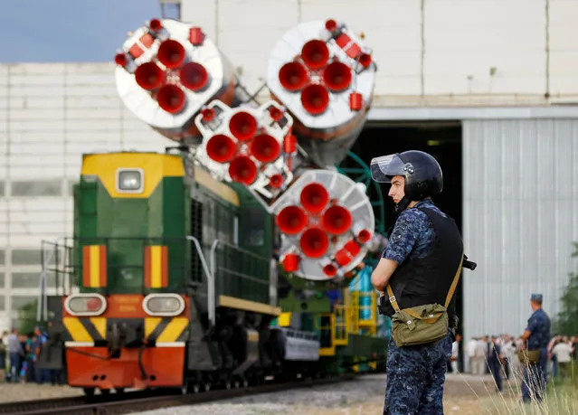 A police officer secures an area as the Soyuz MS spacecraft for the next International Space Station (ISS) crew of Kate Rubins of the U.S., Anatoly Ivanishin of Russia and Takuya Onishi of Japan is ready to be transported from an assembling hangar to the launchpad ahead of its launch scheduled on July 7, at the Baikonur cosmodrome in Kazakhstan July 4, 2016. (Photo by Shamil Zhumatov/Reuters)