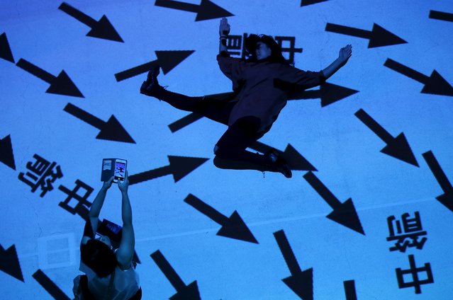 People interact with “Pixel Wave 2015” a projection art installation by France's Miguel Chevalier and local designers Carolyn Kan and Depression that features geometric patterns that react to movements and interactions of people, during the Singapore Night Festival at the Singapore Design Center, August 21, 2015. (Photo by Edgar Su/Reuters)