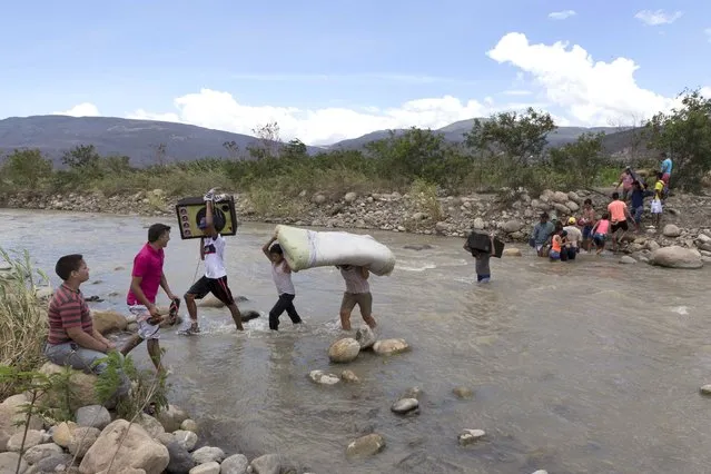 Colombian carry their belongings over from Venezuela as they cross the Tachira river close to Cucuta city, Colombia August 24, 2015. Venezuela has intensified deportations of Colombians since President Nicolas Maduro ordered the closure of two border crossings last week, Colombia's migration office said on Monday, in some cases separating children from their parents. (Photo by Juan Pablo Cohen-La Opinion/Reuters)