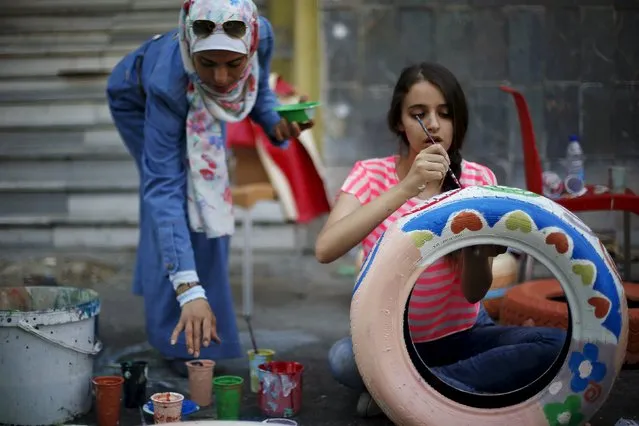 Volunteers paint and decorate tyres during an initiative titled “Hajar-Waraka-Balad” in Amman, Jordan, August 28, 2015. A number of Jordanian volunteers took part in the event organised by Sakeyat Addaraweesh, aiming to paint tyres that will be distributed as seats to decorate Amman's streets. (Photo by Muhammad Hamed/Reuters)