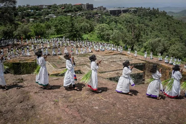 Young women sing during Ashenda festival, at Saint George Church, in Lalibela, Ethiopia, on August 22, 2022. Ashenda Festival is celebrated in Tigray and Amhara regions, group of girls make preparations for the holiday by buying new clothes, visiting hairdressers and the holiday also marks the end of a two-week-long fasting period known as Filseta where the faithful in the Ethiopian Orthodox Tewahedo Church gather to honor the Virgin Mary. After 2 years of war between Ethiopia's Government and Tigray Peoples Liberation Front (TPLF) that took place both in Tigray and Amhara regions it will be celebrated on August 22, 2022 in Lalibela, and girls from neighbouring cities will gather around and celebrate at Church of St. George and Bete Maryam. (Photo by Amanuel Sileshi/AFP Photo)
