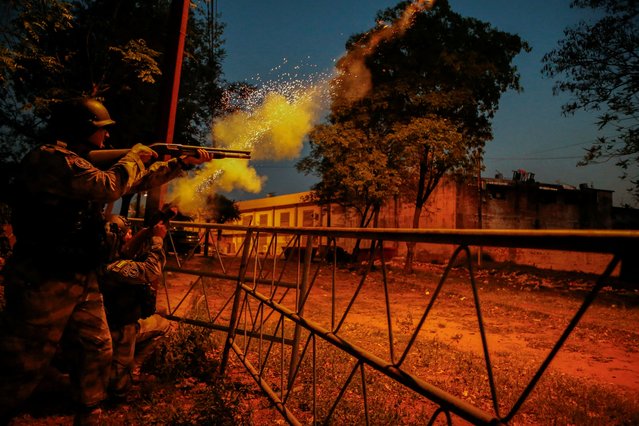Police shoot at the Tacumbu penitentiary after inmates took hostage a dozen officials and caused a fire, in Asuncion, Paraguay on October 10, 2023. (Photo by Cesar Olmedo/Reuters)