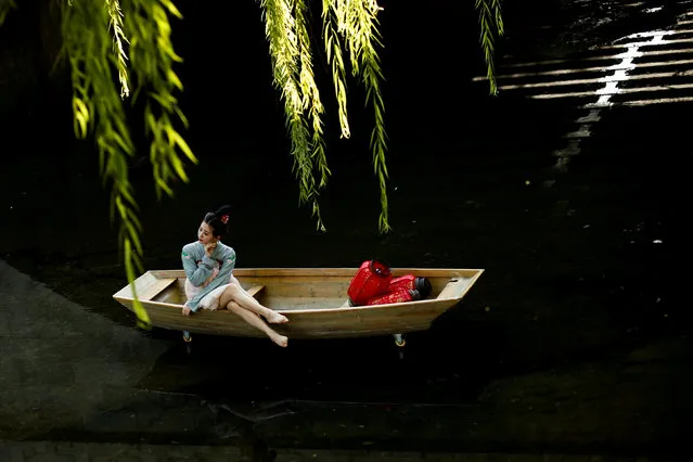 A model poses in a mock-up boat in a shallow canal during a photoshoot in a public park in Beijing, China, September 6, 2017. (Photo by Thomas Peter/Reuters)