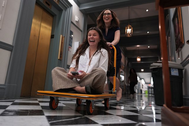 U.S.-Rep.-elect Sarah McBride, D-Del., speeds her incoming Deputy Chief of Staff and Communications Director, Michaela Kurinsky-Malos, through the halls of Delaware Legislative Hall on a moving cart as they move out of McBride's Delaware state senate office in Dover, Del., Tuesday, December 17, 2024. (Photo by Carolyn Kaster/AP Photo)