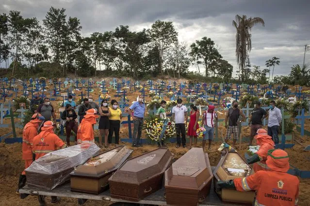 People attend a funeral at a mass grave at the Nossa Senhora Aparecida cemetery in Manaus, Brazil, 23 April 2020. The new section of the cemetery was opened amid a sharp rise in COVID-19 victims. (Photo by Raphael Alves/EPA/EFE)