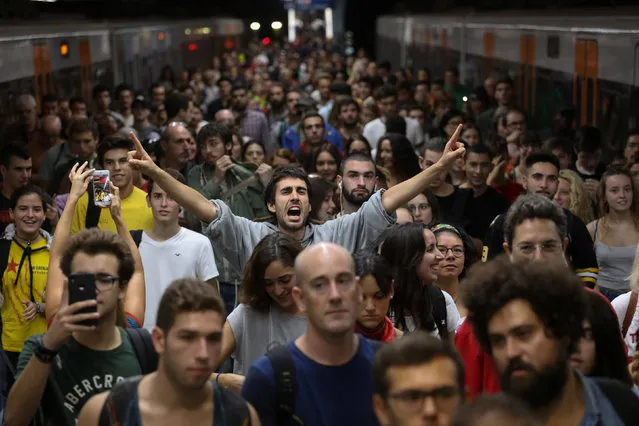 A man shouts slogans as people arrive at Plaza Catalunya station during a partial regional strike called by pro-independence parties and unions in Barcelona, Spain, October 3, 2017. (Photo by Susana Vera/Reuters)